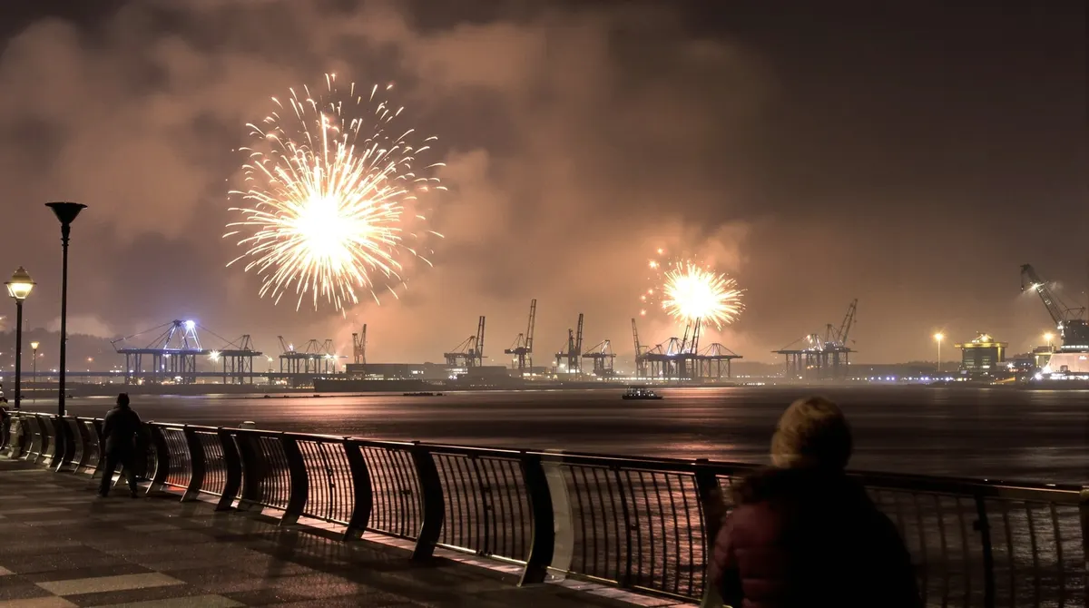 Silvesterfeuerwerk in der Ferne über der Elbe, von den Landungsbrücken aus gesehen