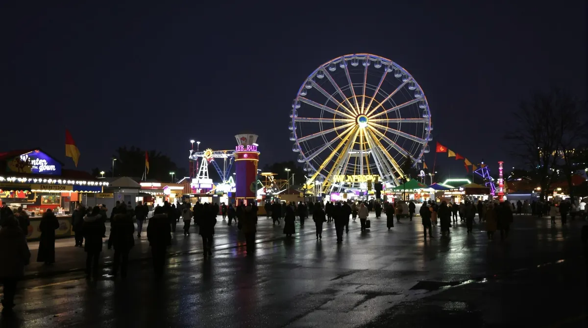 Winterdom auf dem Heiligengeistfeld am Abend mit beleuchtetem Riesenrad und Buden